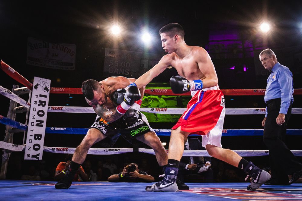 Boxers competing under the lights in a boxing ring